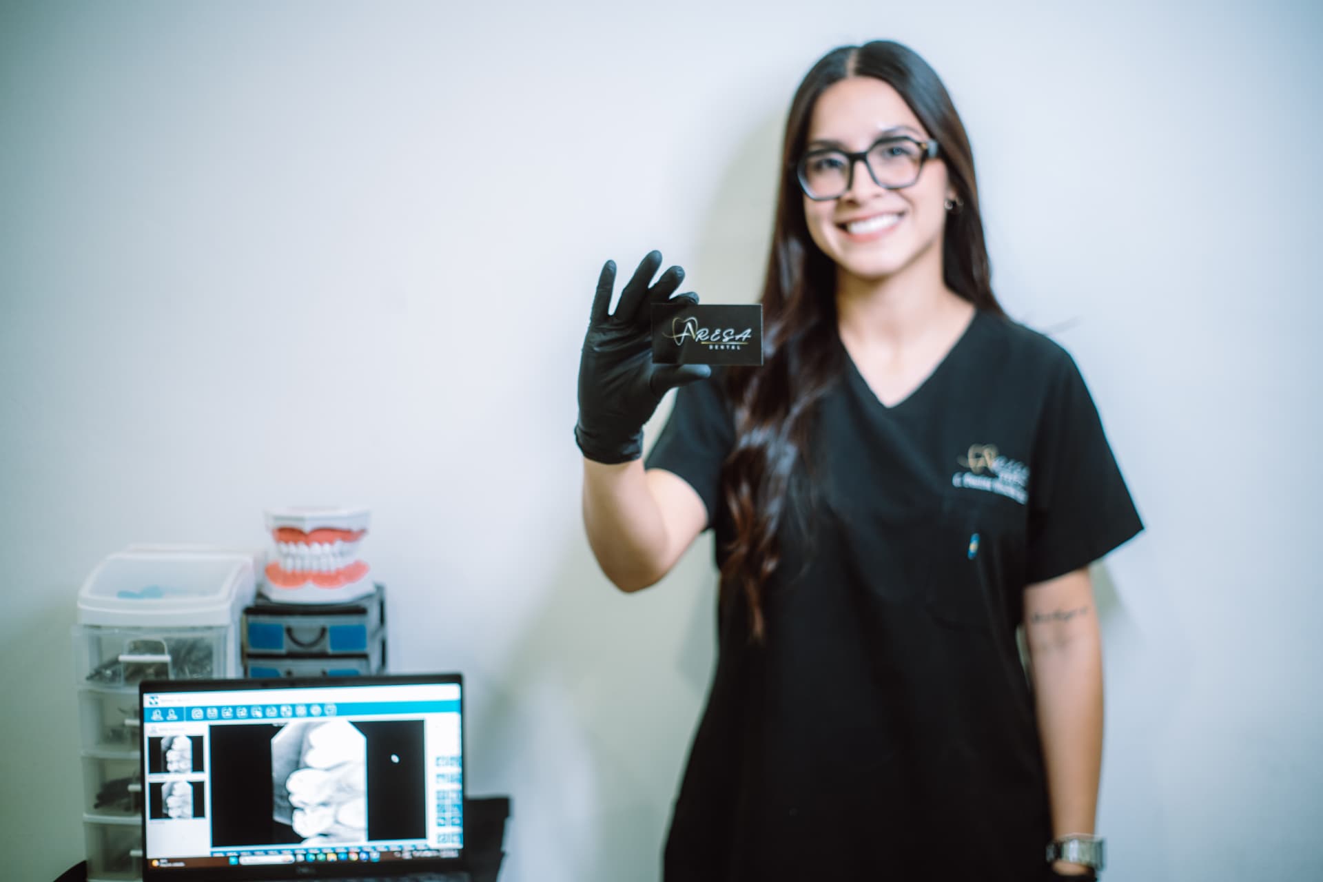 Especialista de Aresa Dental mostrando tarjeta de la clínica