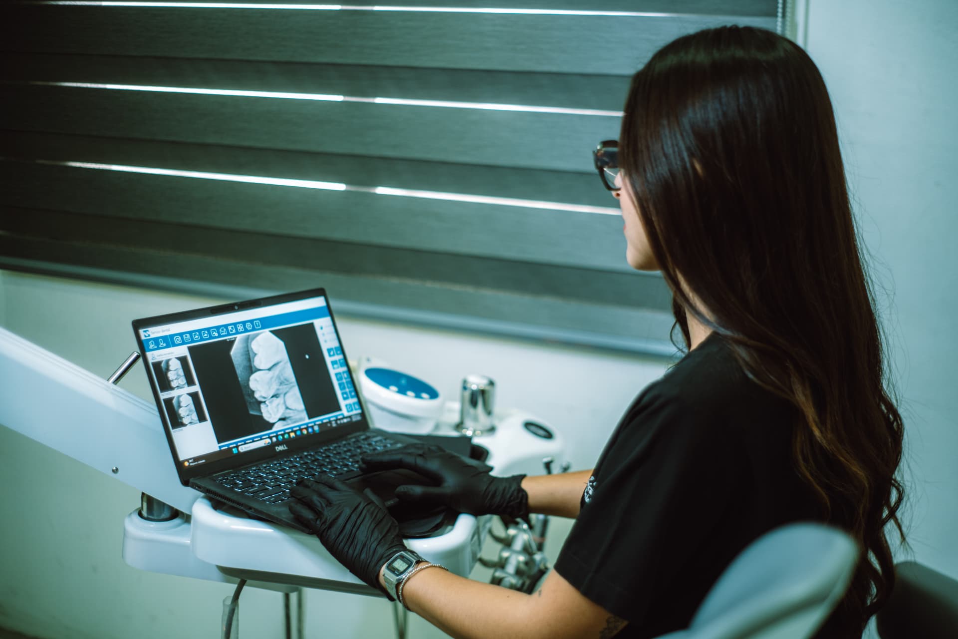 Odontóloga de Aresa Dental revisando una radiografía dental en la computadora